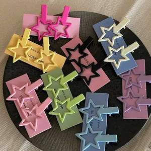 Dettaglio di fermagli per capelli a stella opachi colorati su schede di presentazione