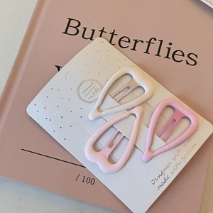 Détail de trois barrettes cœur rose mat dégradé présentées sur une carte artisanale