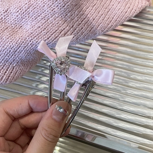 Details von cremigen rosa Schleifen-Haarspangen mit Herz-Strassstein und silbernem Metallclip