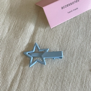 Dettaglio del fermaglio per capelli a stella azzurro opaco su sfondo in tessuto