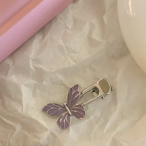Elegant purple butterfly hair clip with metallic silver base on a soft white background