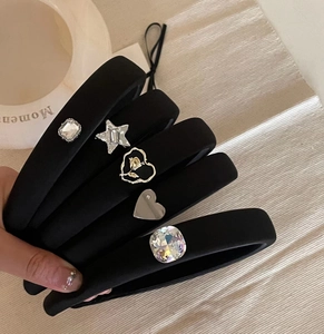Detailed macro view of black velvet padded headbands with various rhinestone ornaments