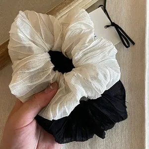 Eleganti elastici per capelli increspati in bianco e nero con design minimalista