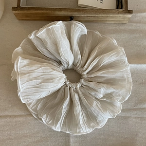 Chouchou chic a pieghe crema oversize elastico per capelli su sfondo di lino minimal