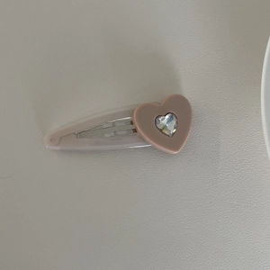 Detailaufnahme der rosa Herz-Haarspange mit funkelndem Strassstein und Glanz
