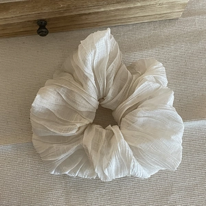 Vista dettagliata di un elastico per capelli bianco plissettato in morbido chiffon a strati