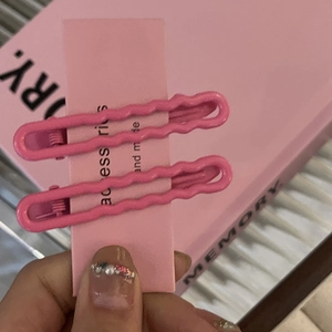 Nahaufnahme der rosa matten Wellen-Haarklammern aus Metall auf Display-Karte