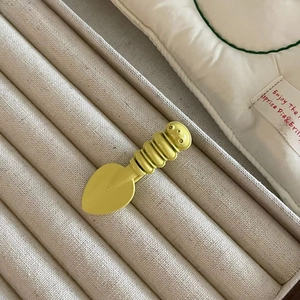 Detailed macro view of a cute caterpillar style light yellow metal hair clip on a display tray