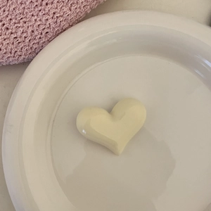 Gros plan d'un accessoire à cheveux en forme de cœur crème sur une assiette blanche