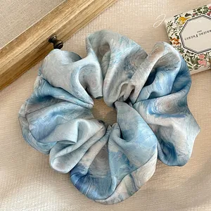 Vue détaillée du chouchou élégant avec motif de lavage à l'encre et tissu plissé