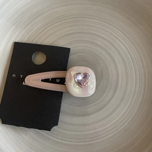 Pink heart crystal hair clip with gradient rhinestones on beige ceramic plate