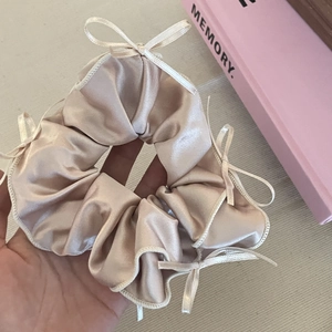 Elegant champagne satin scrunchie with white ribbon bows in a French vintage ballet style