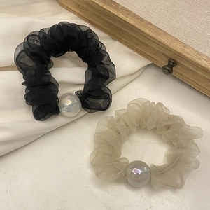 Detailed macro view of chiffon organza hair scrunchies with iridescent faux pearls and pleats