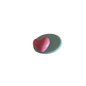 Accessoire cheveux en résine rose en forme de cœur avec base ovale vert clair sur fond blanc