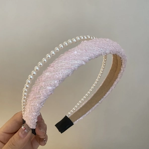 Close-up of pink tweed headband with white pearl trim and non-slip inner lining