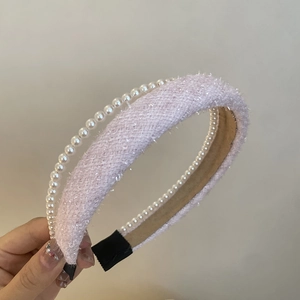 Detail of pink tweed fabric headband with elegant white pearls and comfortable black tips