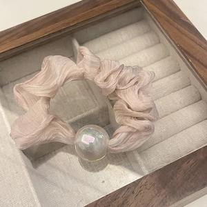 Close-up of pink pleated chiffon scrunchie with a large iridescent pearl decoration