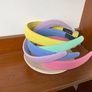 Detail view of handmade macaron sponge headbands in pastel fabric with woven label