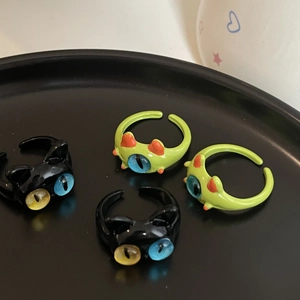 Detalle de anillos de dibujos animados de gatos y monstruos con acabado brillante