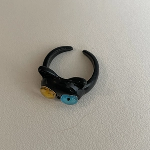Detalle del anillo de gato negro con ojos heterocromáticos únicos en amarillo y azul