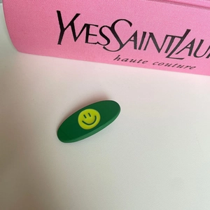 Cute green matte oval hair clip featuring a vibrant yellow smiley face pattern for women