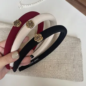 Three elegant French sponge headbands in black, cream, and wine red with gold rose accents