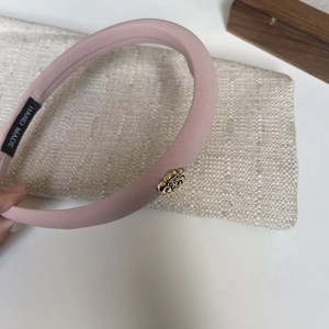 Pink fabric camellia headband with a vintage gold rose accent for a minimalist elegant look