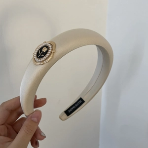 Détail d'un serre-tête camélia fait main avec perles et texture satinée élégante