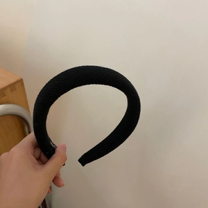 Detailed close-up of thick black plaid knit headband with high sponge padding