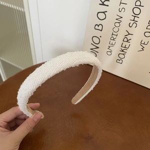 Close-up of cream white tweed headband with soft textured fabric and non-slip lining