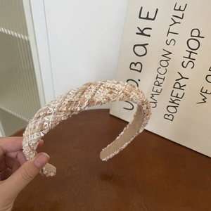 Detailed macro view of the pink tweed headband texture with shimmering sequins and gold thread