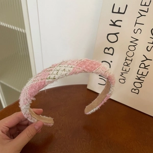 Detailed view of pink and white plaid tweed headband with brown non-slip inner lining