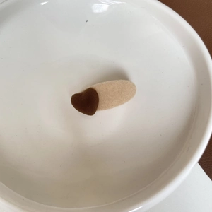 Detailed view of milk tea brown heart-shaped flocked hair clip on a white ceramic plate