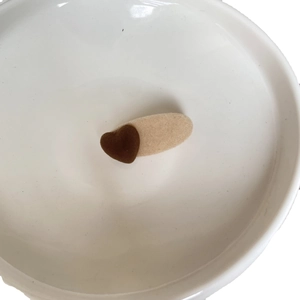 Cute milk tea beige flocked heart hair clip for women on a white ceramic plate