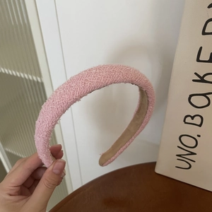 Close-up of pink tweed fabric texture and soft velvet lining on wide hairband