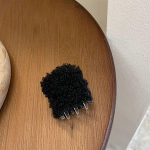 Petite pince à cheveux en fausse fourrure noire avec texture peluche et clip transparent