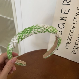 Detail of green and white tweed headband showing thick woven texture and beige lining