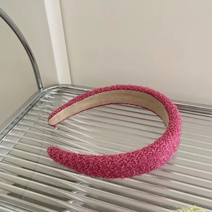 Detail of rose pink textured fabric headband with subtle sparkles and anti-slip suede lining