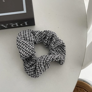 Close-up of black and white tweed hair scrunchie texture with elegant fabric details