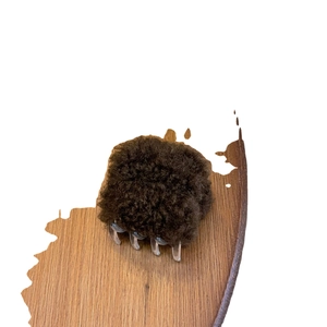 Pince à cheveux en fausse fourrure marron avec dents en résine sur support en bois