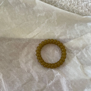 Olive green spiral telephone wire hair tie on white background for women ponytail