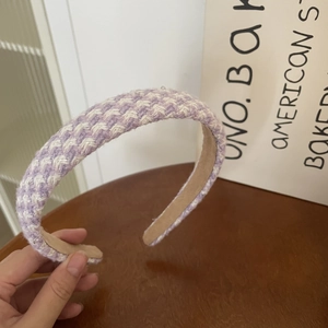 Detailed macro view of purple and white houndstooth wool headband with non-slip lining