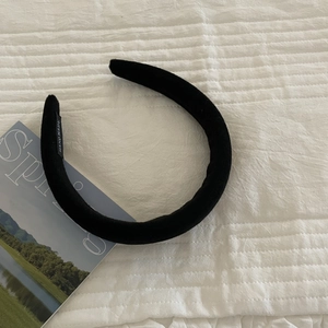 Thick black velvet padded headband with handmade label on white quilted background