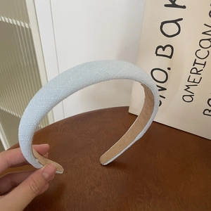 Detail of light blue checkered wool headband with thick padding and non-slip lining