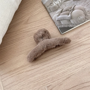 Braune flauschige Haarklammer aus Kunstpelz für Damen in gemütlichem Innenbereich