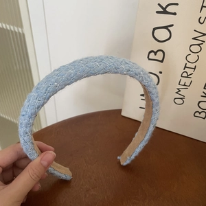 Detailed close-up of light blue tweed headband with silver thread and non-slip lining