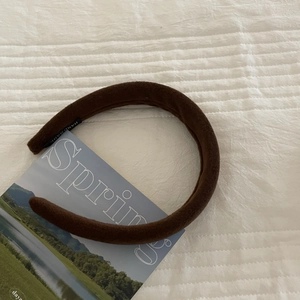 Handmade deep brown velvet padded headband for women on a cozy white quilted fabric