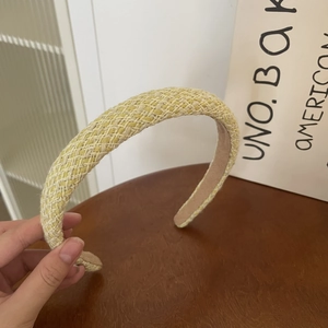 Detail of light yellow woven headband showing cross-stitch texture and thick sponge padded base