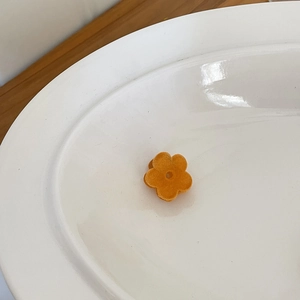 Detailaufnahme einer kleinen orangefarbenen beflockten Blumen-Haarklammer mit Samt