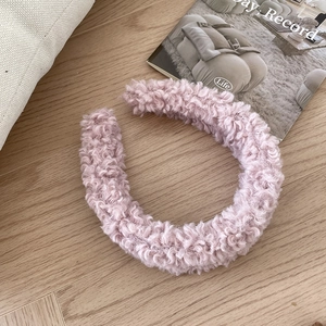 Detailed texture of thick pink faux lamb wool headband with padded wide brim design